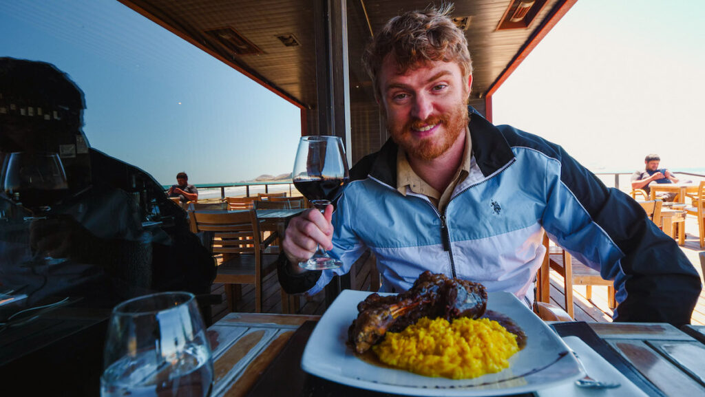 Samuel eating Patagonian lamb and risotto at a restaurant in Rada Tilly 