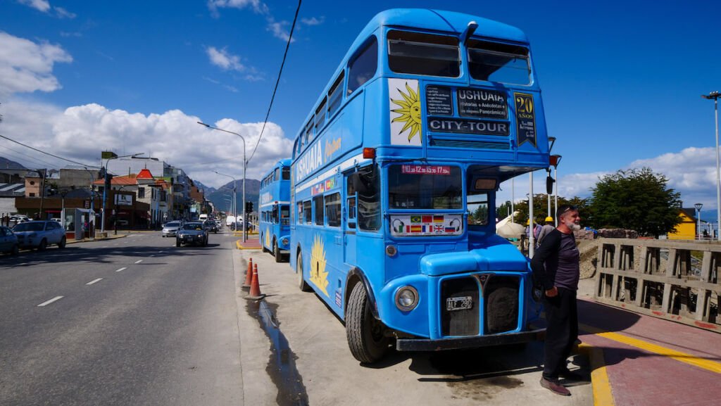 Ushuaia city tour aboard a blue double-decker bus.