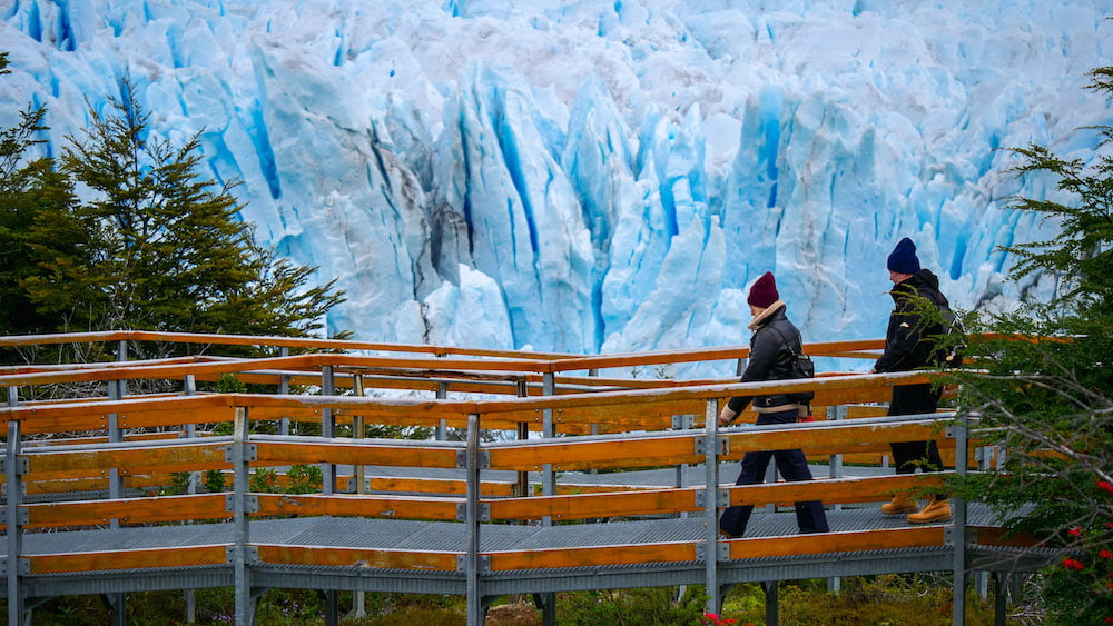 Visitors walking the boardwalk in Los Glaciares National Park with Perito Moreno Glacier in the background 
