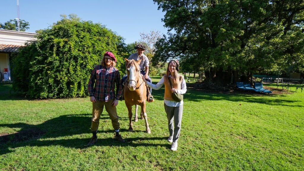 Samuel and Audrey posing with a gaucho and his horse while visiting Estancia El Ombu 