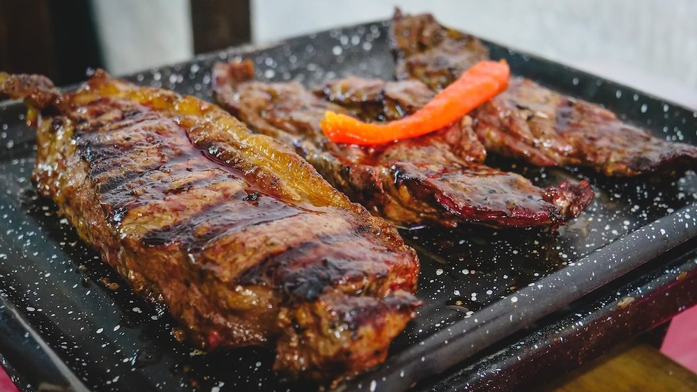 Steak on a small grill served at a parrilla restaurant