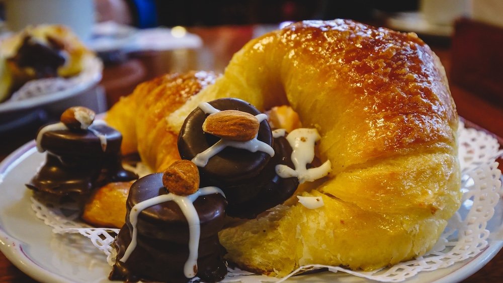 A plate of medialunas and mini alfajores covered in chocolate at Las Violetas cafe in Buenos Aires