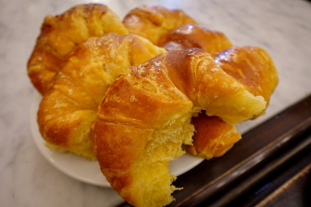 A plate of fluffy, sweet medialunas that can be enjoyed with coffee for a traditional Argentine breakfast.