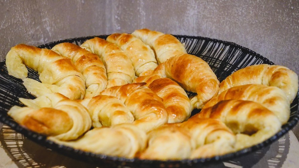 A plate of butter medialunas covered in a sweet glaze