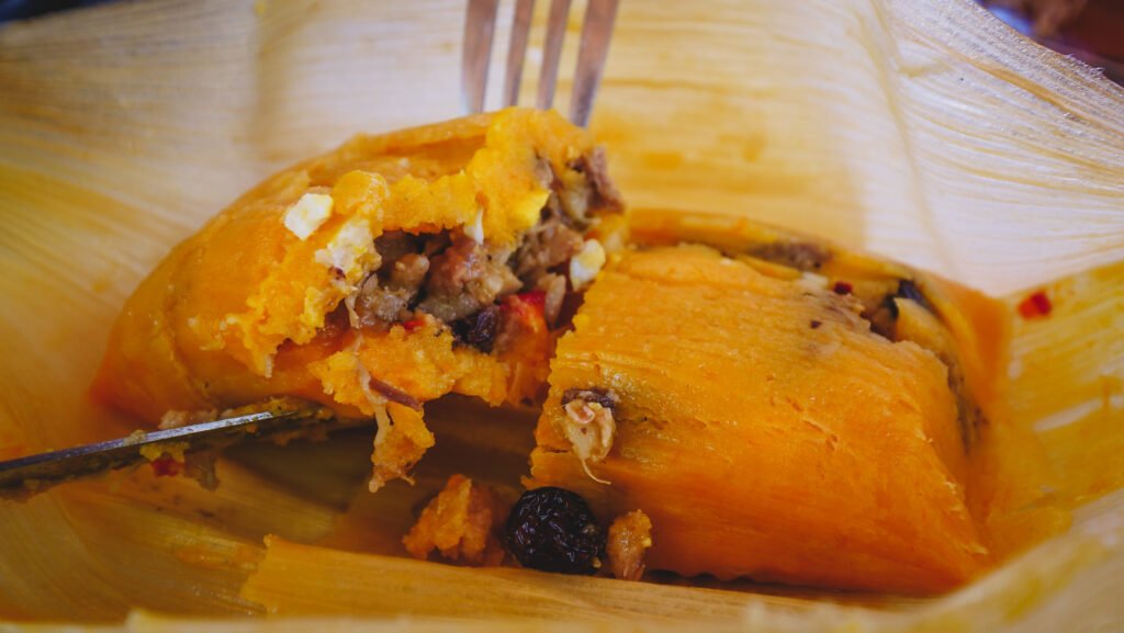 Tamales consist of corn flour stuffed with meat and steamed in a corn husk.