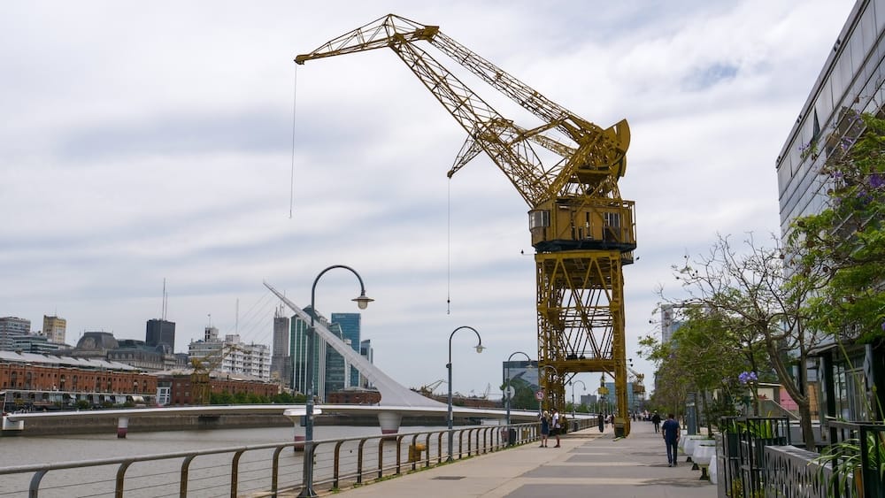 A yellow crane stands along the promenade of the old docks in Puerto Madero, as an industrial sculpture that pays homage to the port's past.