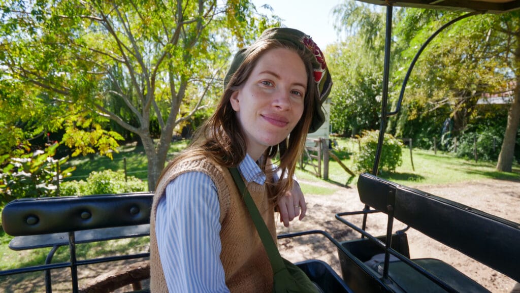 Audrey Bergner, founder of Che Argentina Travel, wearing a traditional boina (beret) in a vintage carriage in San Antonio de Areco, the capital of Argentine gaucho culture.