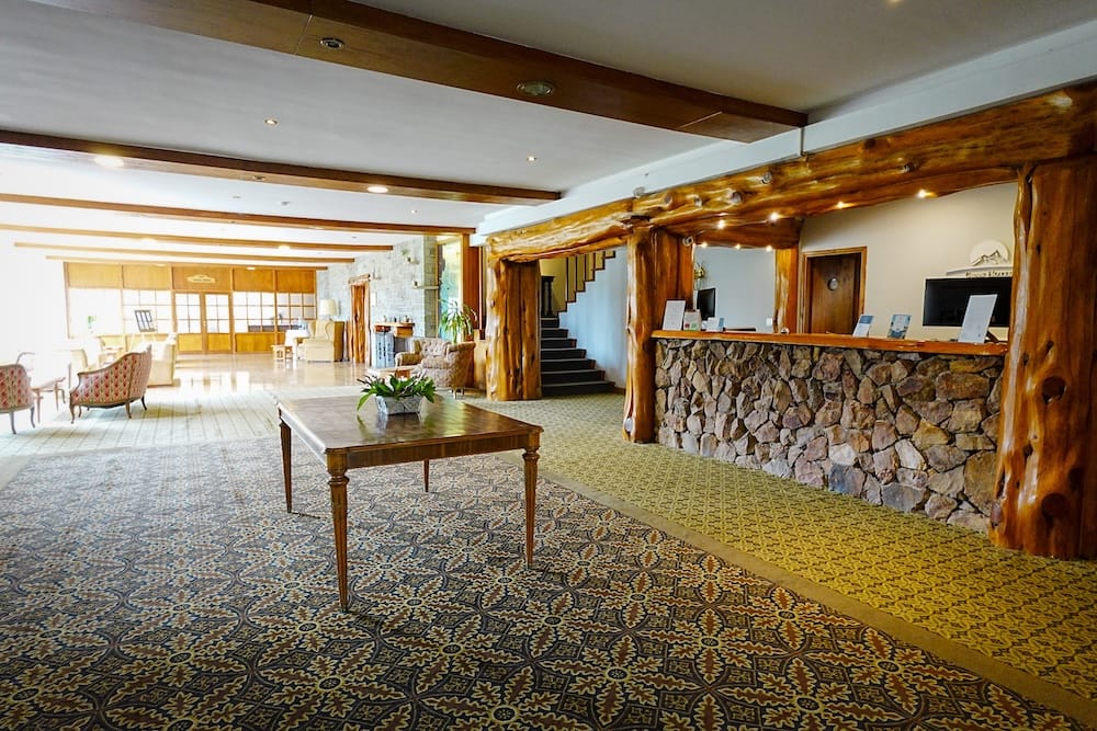 The lobby at Gran Hotel Panamericano features a stone reception desk and lots of rustic tree logs.