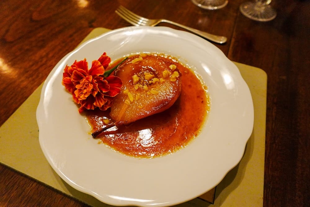 Caramelized pear with chopped walnuts served for dessert.