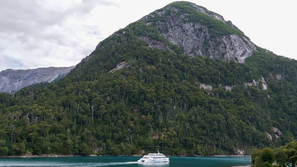 Catamaran leaving Port Blest with a large mountain in the background.