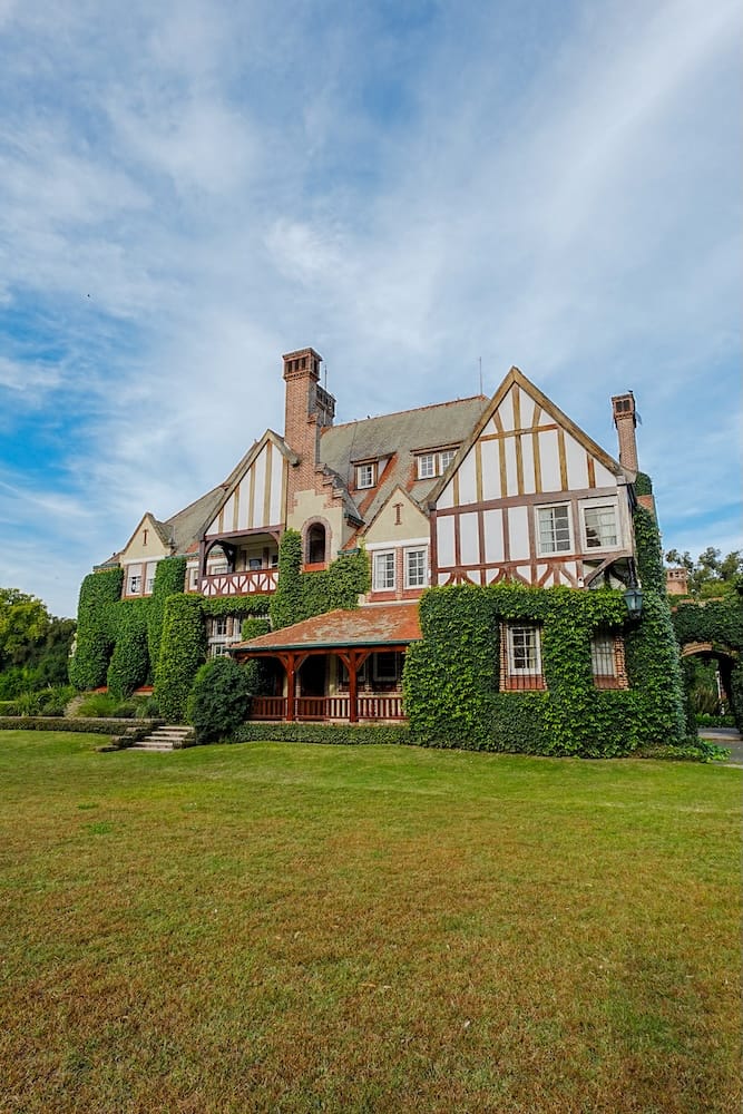 Estancia Villa Maria with its Tudor-style architecture and a green lawn.