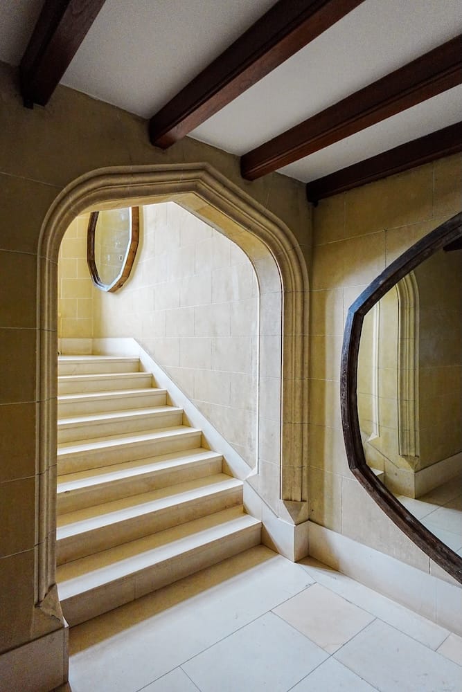 Marble staircase, stone arches, and natural light bouncing off the mirror at Estancia Villa Maria.
