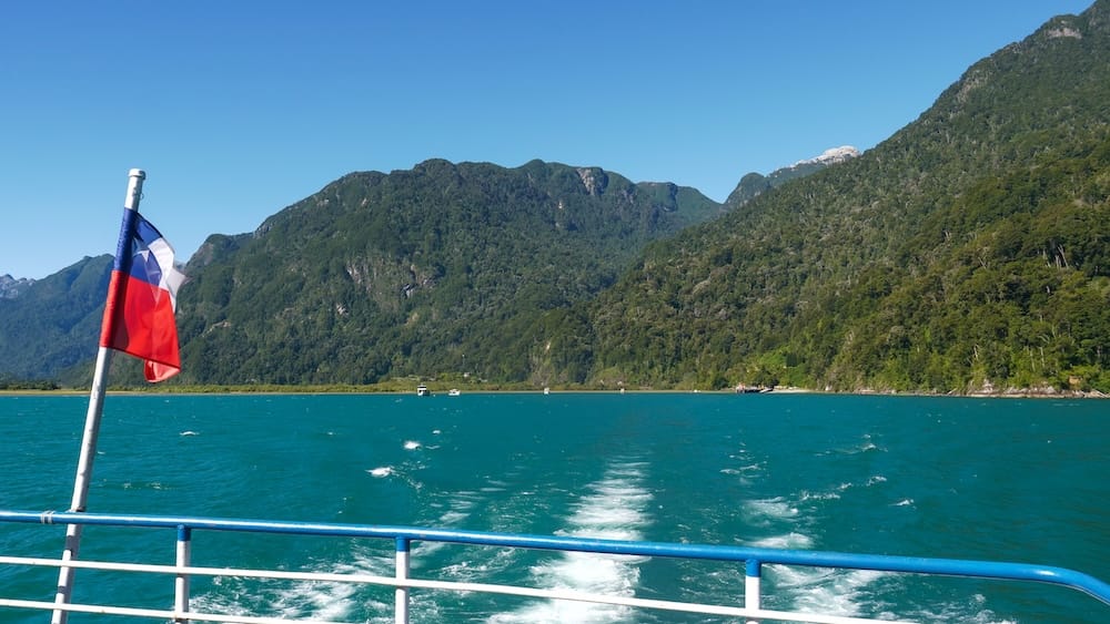 Chilean flag blowing in the wind as we cross Lago Todos los Santos by boat on our Andean Crossing.